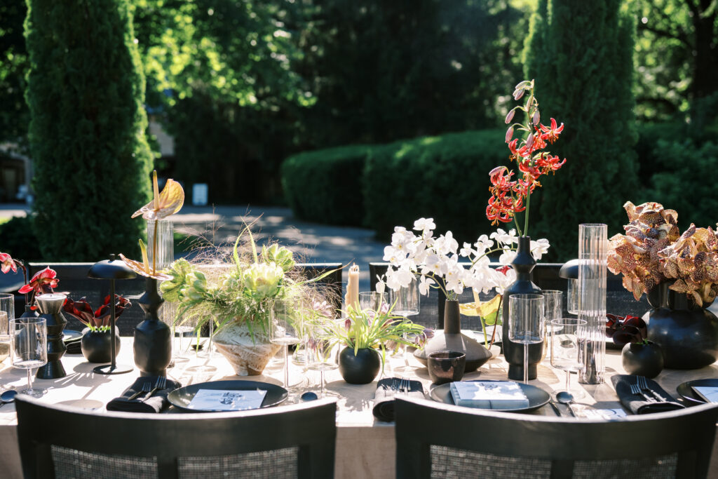 Elegant outdoor wedding table with artistic floral arrangements at Greencrest Manor, captured by Lexie Vaccaro Photography. A refined black and neutral tablescape with modern luxury details.