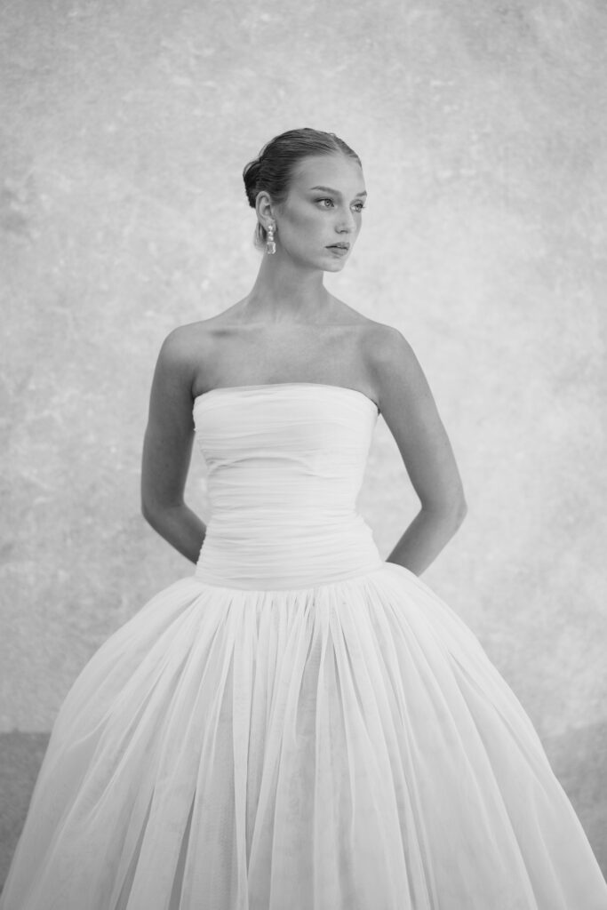 A black-and-white portrait of a bride in an elegant strapless gown, exuding timeless sophistication and editorial beauty.