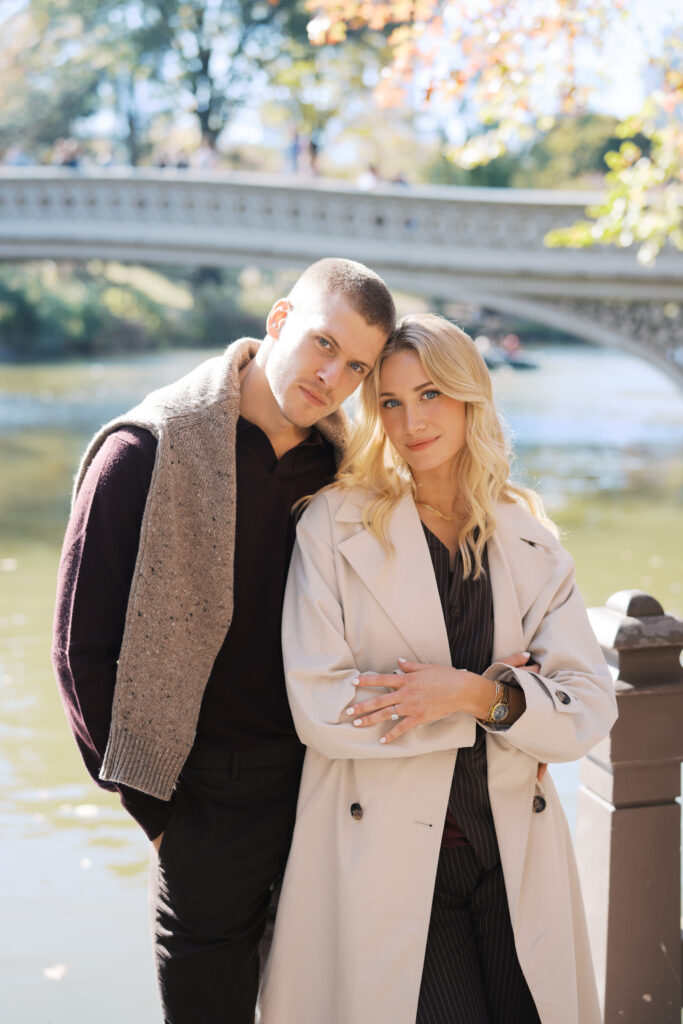 Fashion-forward couple at Bow Bridge in Central Park during a fall engagement session, photographed by Lexie Vaccaro Photography.