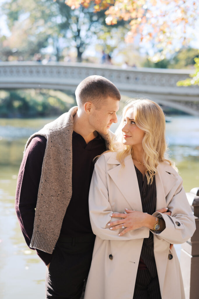 Close-up of a stylish couple at Bow Bridge during a fall Central Park engagement session, photographed by Lexie Vaccaro Photography.