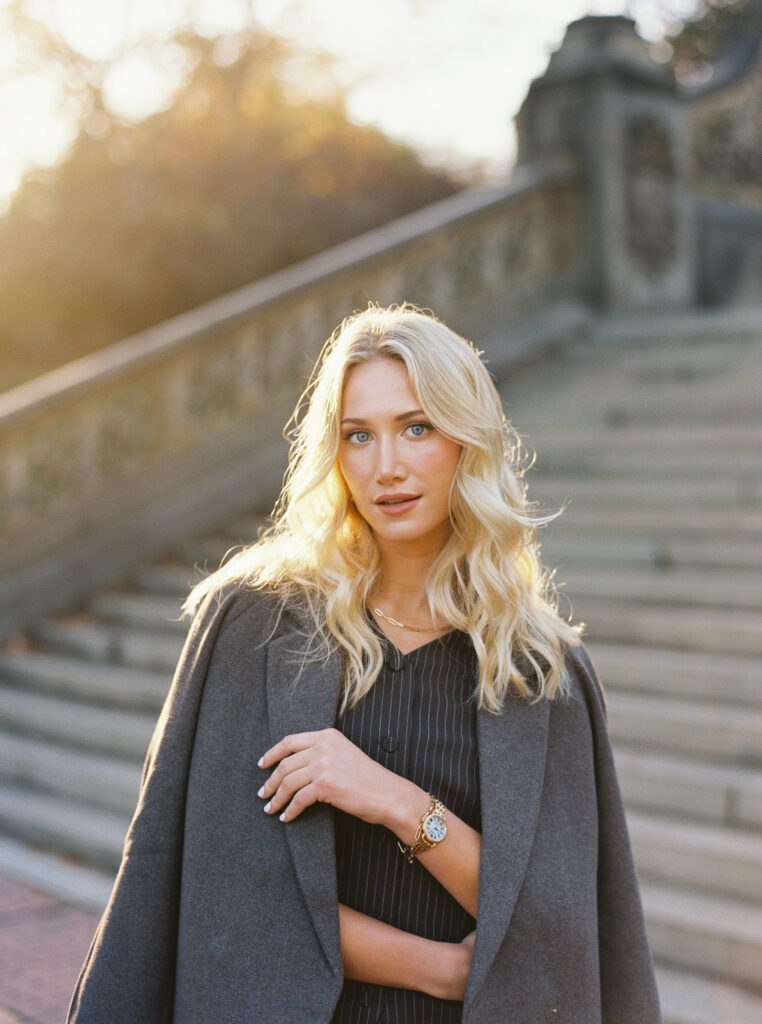 Golden-hour portrait of a blonde woman in chic fall fashion at Bethesda Terrace in Central Park, photographed on film by Lexie Vaccaro Photography.