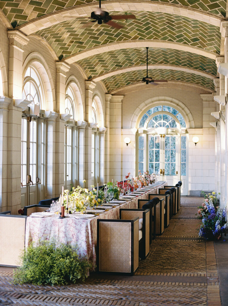 Fall wedding reception tablescape inside Purslane at the Boathouse in Prospect Park with color-blocked florals and cane-backed chairs