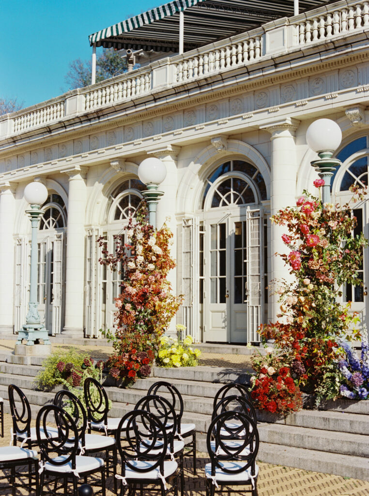 Vibrant floral pillars on the stone steps of Purslane at the Boathouse in Prospect Park, captured on film by Lexie Vaccaro Photography