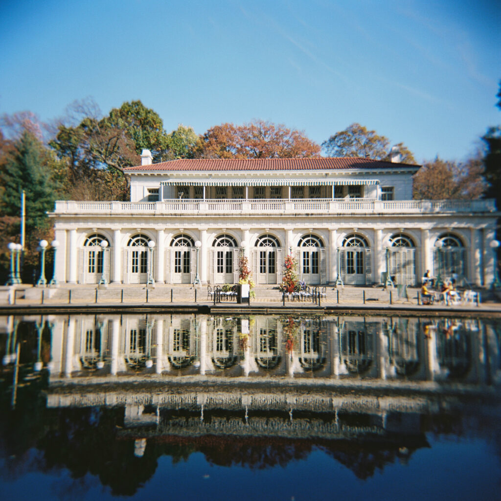 Film photo of Purslane at the Boathouse in Prospect Park with full reflection in the water and fall trees in the background
